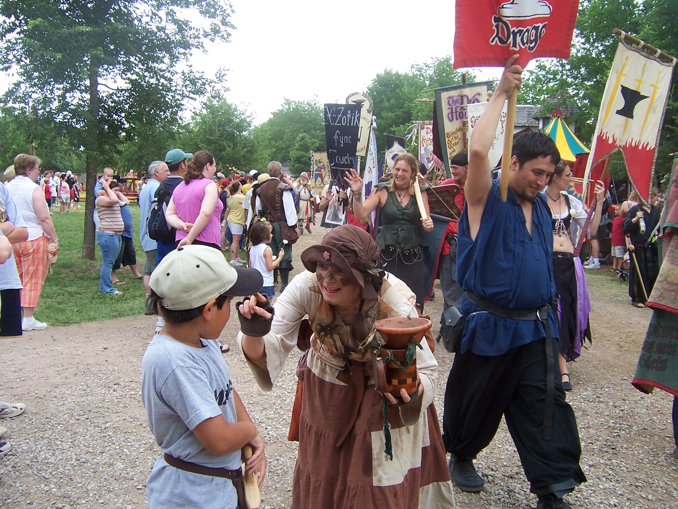 A paradee is touching Jacksons face. Every day they have a parade at Scarborough Faire. There are several hundred participants including the King and the Queen